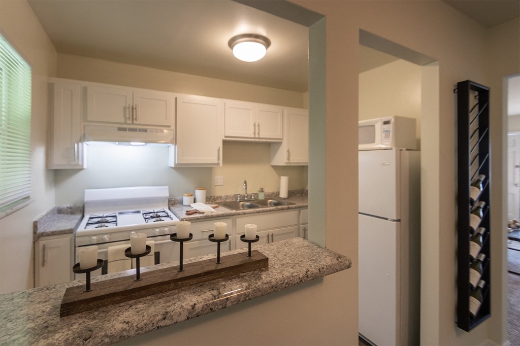 This is a photo of the kitchen with pass through breakfast bar of the 550 square foot 1 bedroom, 1 bath, balcony floor plan model apartment at College Woods Apartments in thne NOrth College Hill neighborhood of Cincinnati, OH.