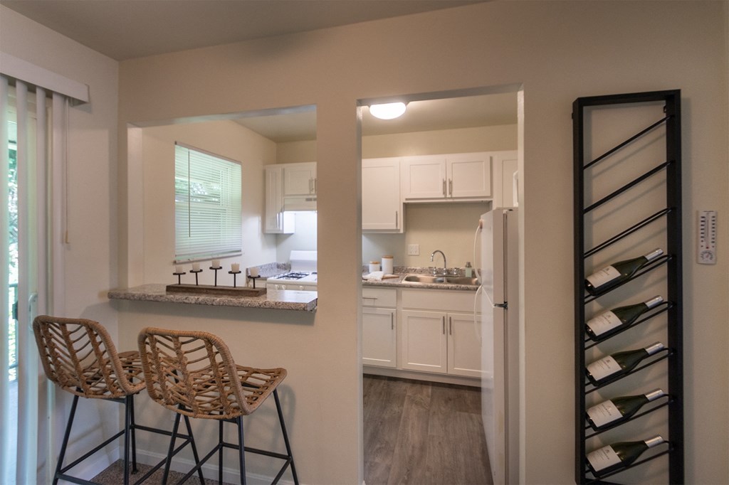 This is a photo of the kitchen with pass through breakfast bar of the 550 square foot 1 bedroom, 1 bath, balcony floor plan model apartment at College Woods Apartments in thne NOrth College Hill neighborhood of Cincinnati, OH.