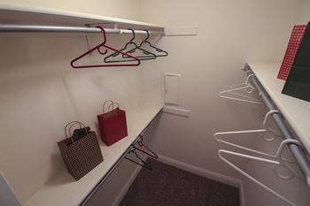 This is a photo of the walk-in closet in the 692 square foot 1 bedroom model apartment at Cambridge Court Apartments in Dallas, TX.