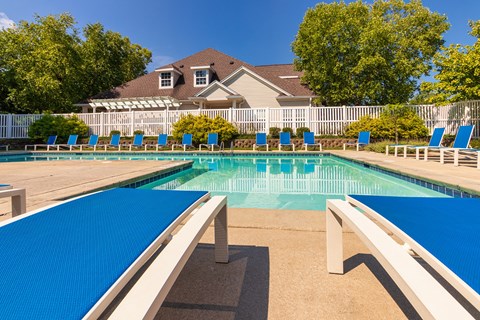 A large blue swimming pool with a white fence by the clubhouse at Fairfield Pointe Apartments in Fairfield, Ohio.