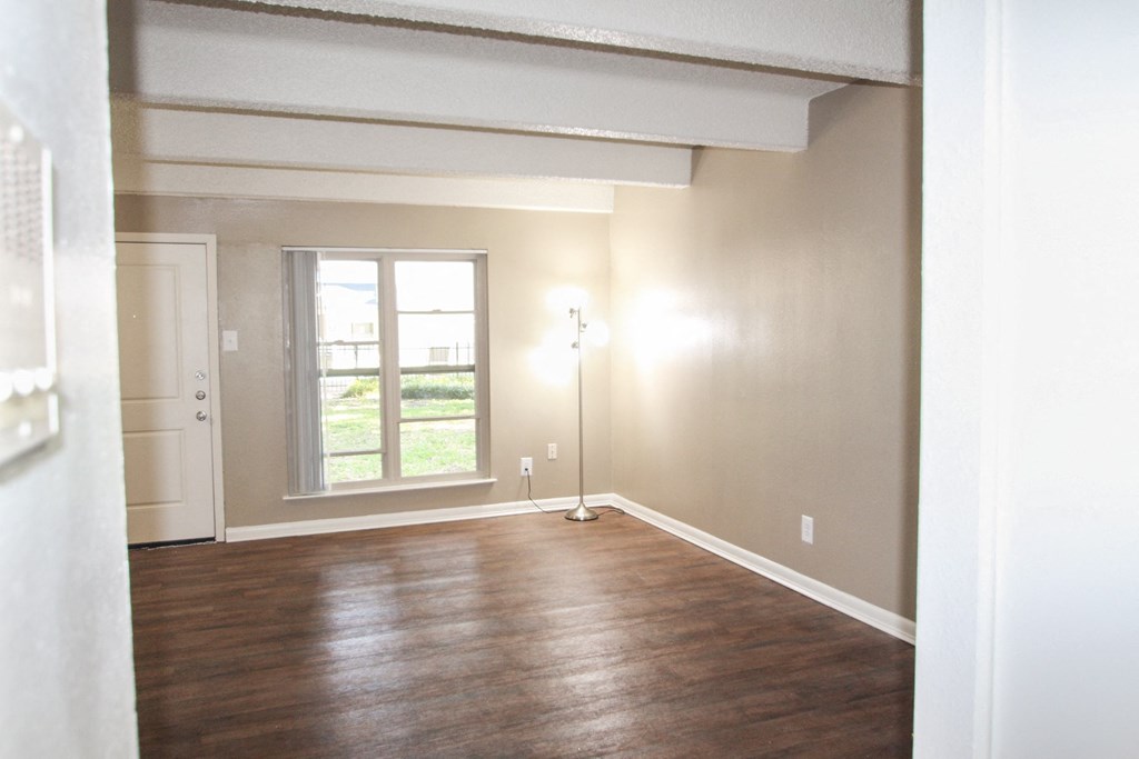 This is a photo of the living room from the kitchen of the 653 square foot 1 bedroom apartment at Harvard Square Apartments, in Dallas, TX.