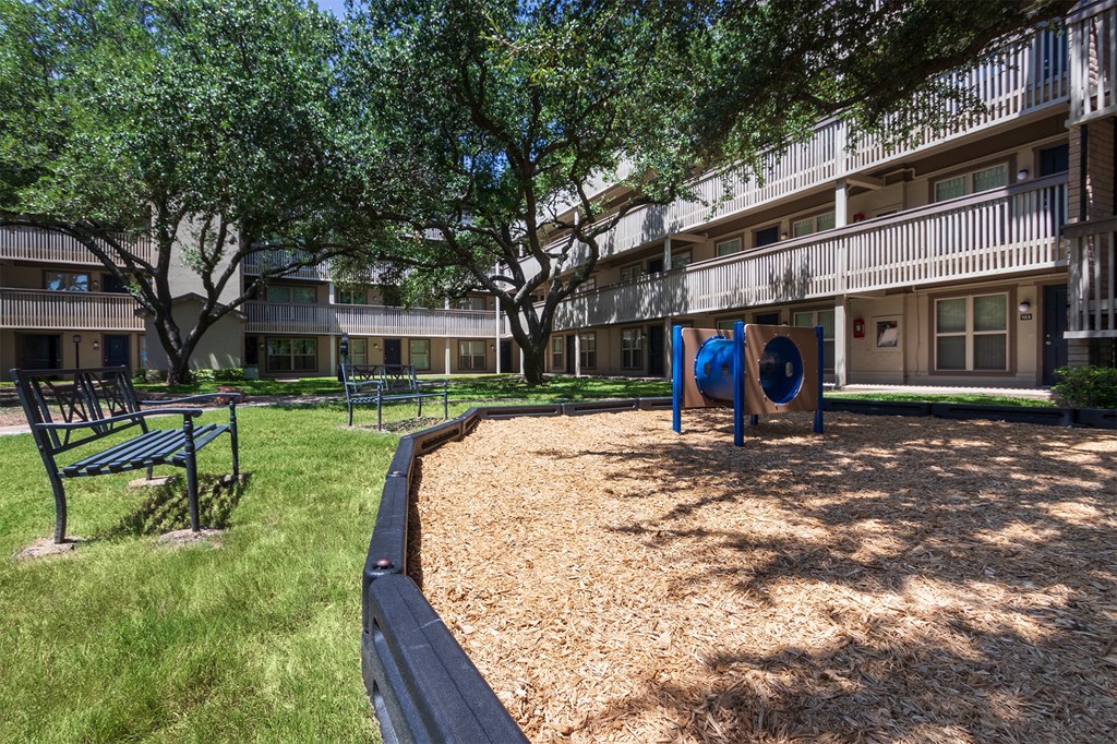 This is a photo of a couple of benches by the playground in the courtyard at Harvard Square Apartments, in the Vickery Meadow neighborhood of Dallas, TX.