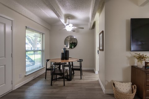 Dining area and living room view with large window in a one-bedroom apartment home at Harvard Square Apartments