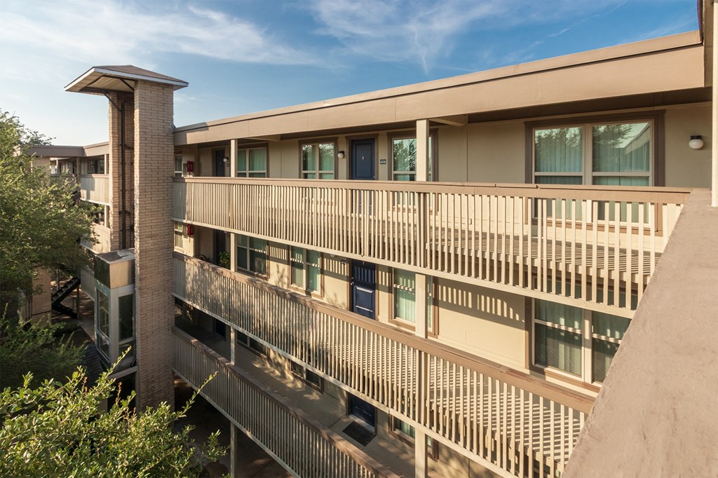 This is a photo of apartment entrances in the courtyard at Harvard Square Apartments, in the Vickery Meadow neighborhood of Dallas, TX.