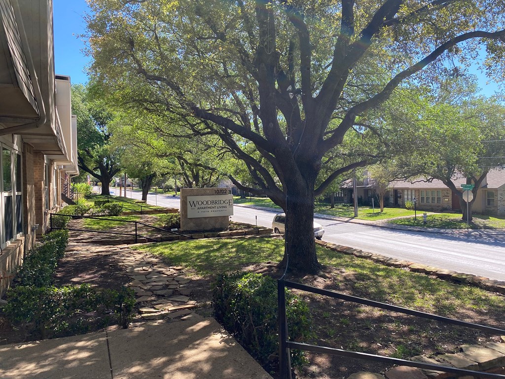 This is a photo of building exteriors and the grounds at Woodbridge Apartments in Dallas, Texas.