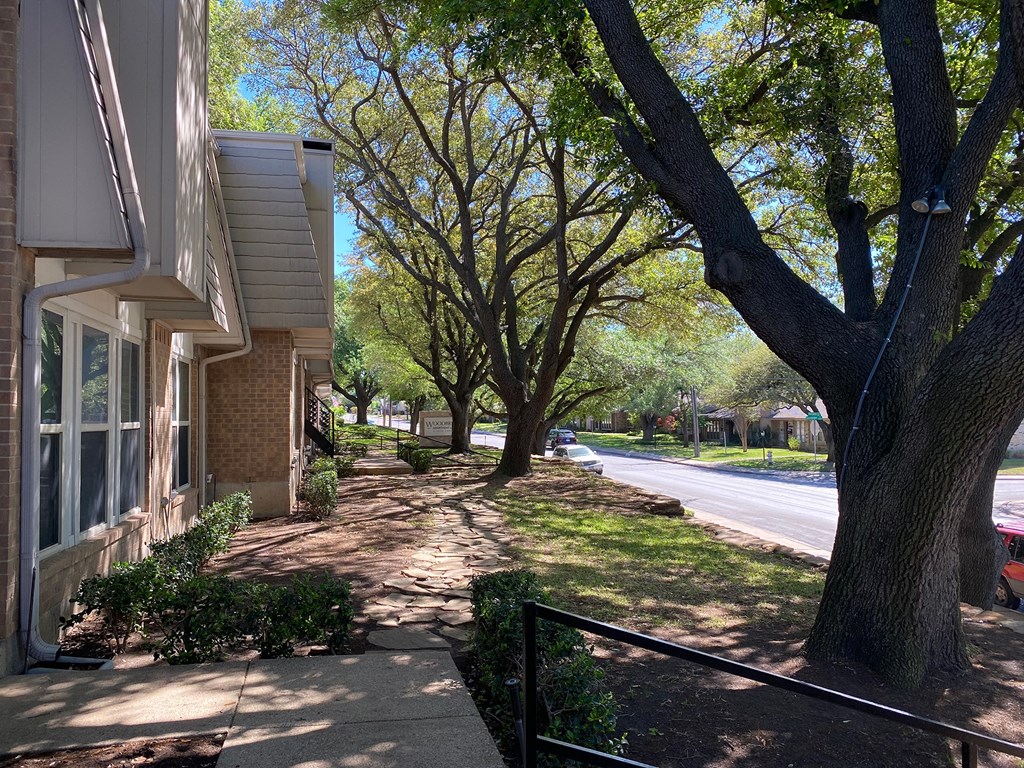 This is a photo of building exteriors and the grounds at Woodbridge Apartments in Dallas, Texas.