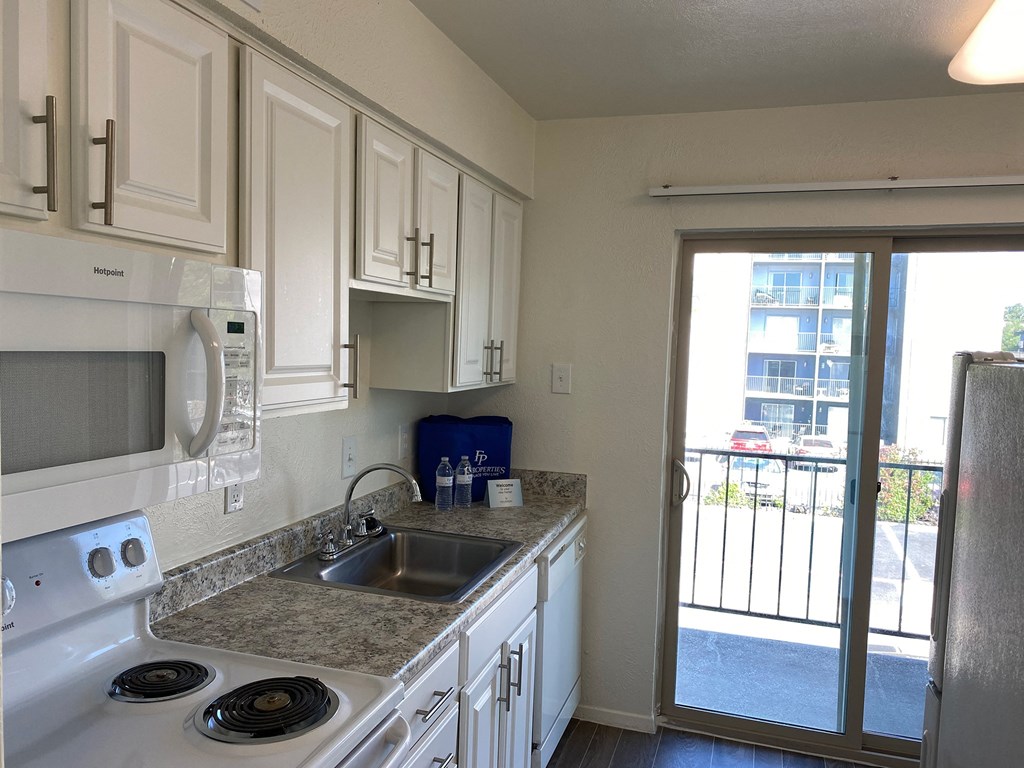 a kitchen with white cabinets and a sink and a window