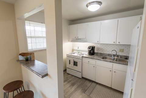 This is a photo of the kitchen and breakfast bar of the 1 bedroom, 631 square foot model apartment at Lake of the Woods Apartments in Cincinnati, OH.