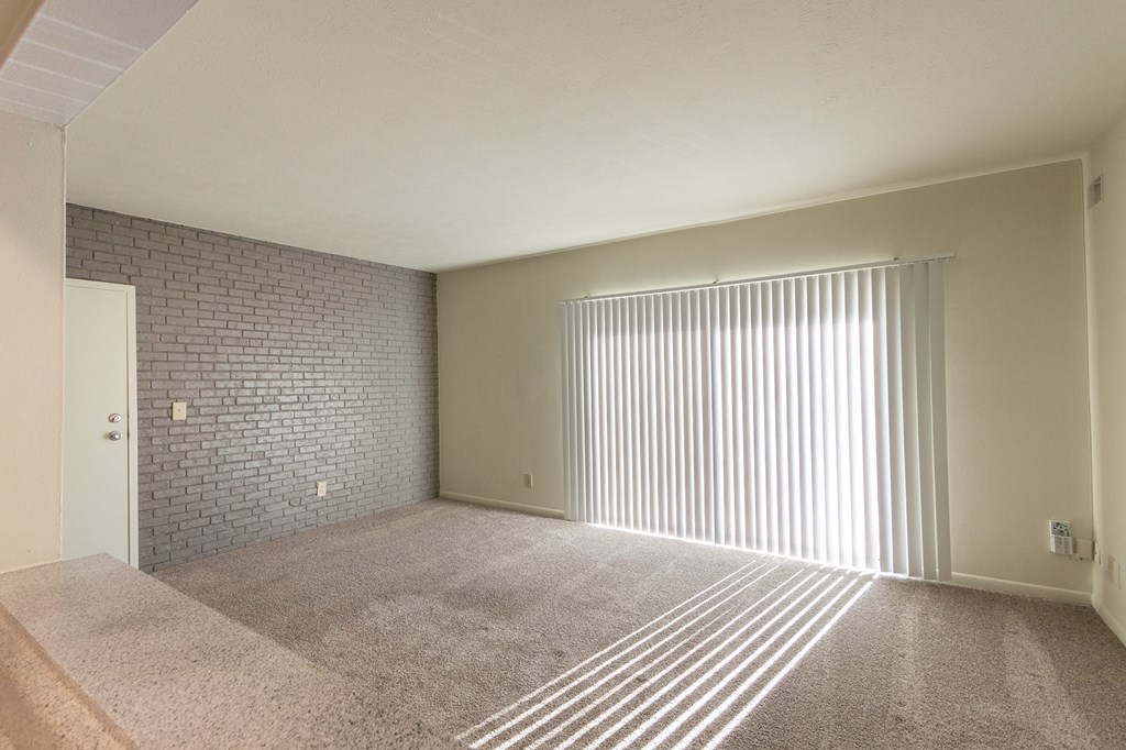 This is a photo the living room with painted brick accent wall of the 833 square foot Chestnut, 2 bedroom apartment at Montana Valley Apartments in Cincinnati, OH.