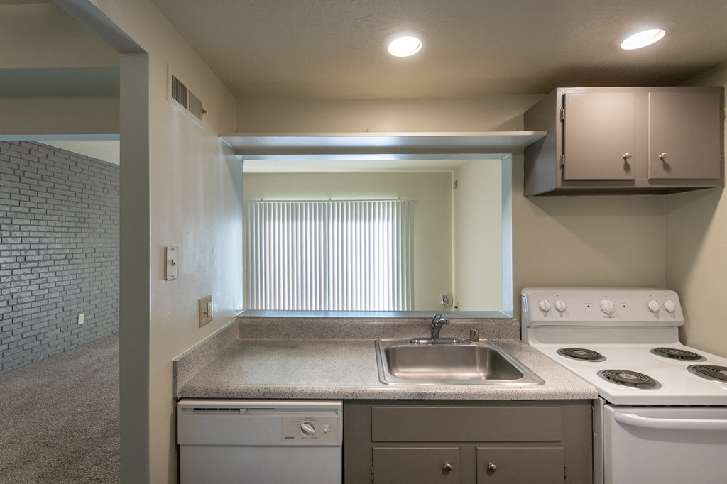 This is a photo the living room with painted brick accent wall from the kitchen of the 833 square foot Chestnut, 2 bedroom apartment at Montana Valley Apartments in Cincinnati, OH.