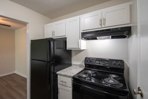 a kitchen with black appliances and white cabinets and a black refrigerator