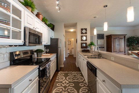 a large kitchen with white cabinets and black appliances