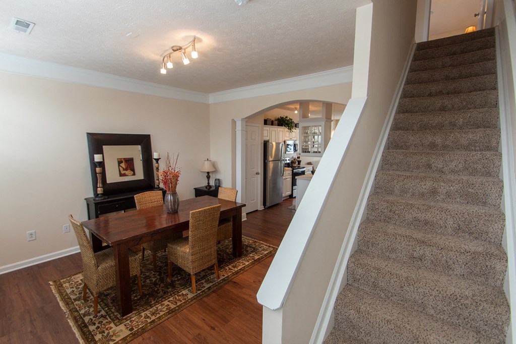 This is a photo of the dining room and stairwell in the 1242 square foot, 2 bedroom, 2 and 1/2 bath Spinnaker floor plan at Nantucket Apartments in Loveland, OH.