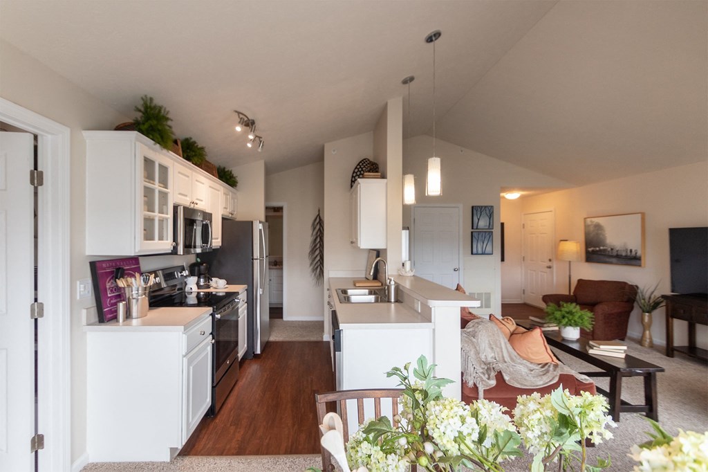 This is a photo of the kitchen and living room from the dining area in the 1016 square foot, 2 bedroom, 2 bath Nautica floor plan at Nantucket Apartments in Loveland, OH.