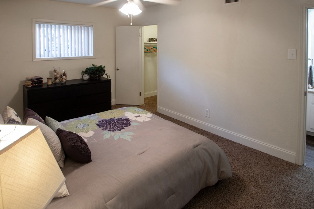 a bedroom with a bed and a dresser and a window