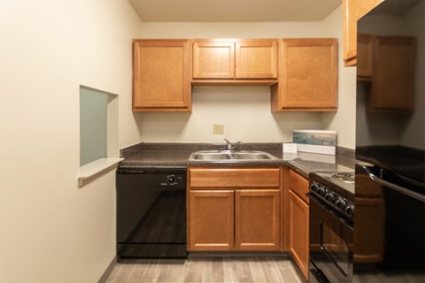 This is a photo of a kitchen with honey oak cabinets and black appliances in a 560 square foot 1, 1 bath apartment at Park Lane Apartments in Cincinnati, OH.