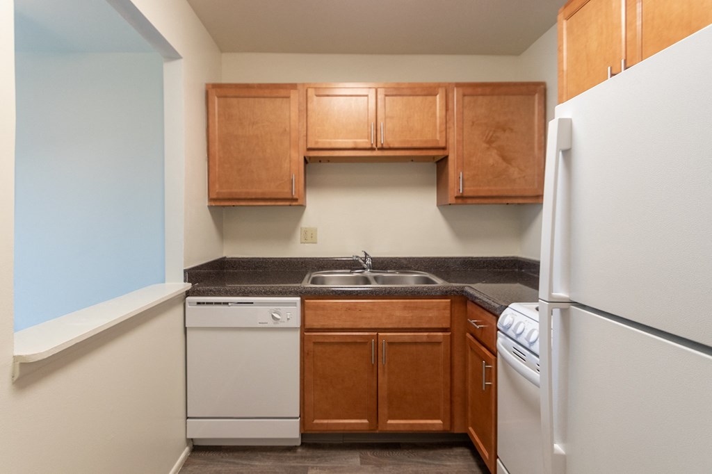 This is a photo of a kitchen with honey oak cabinets and white appliances in a 560 square foot 1, 1 bath apartment at Park Lane Apartments in Cincinnati, OH.