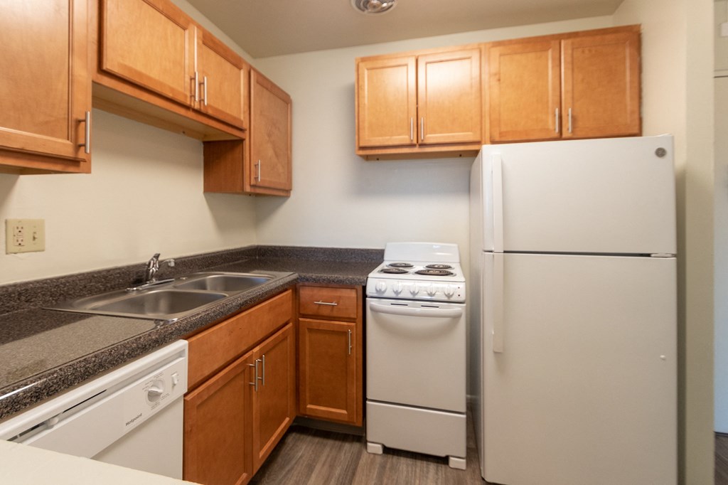 This is a photo of a kitchen with honey oak cabinets and white appliances in a 560 square foot 1, 1 bath apartment at Park Lane Apartments in Cincinnati, OH.