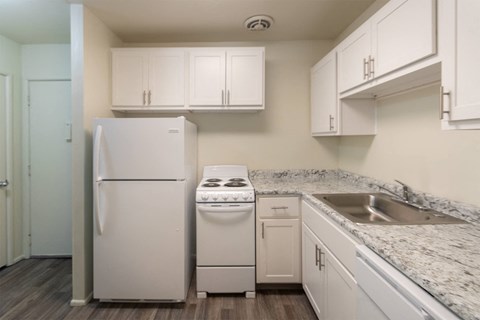 This is a photo of a kitchen with white cabinets and white appliances in a 560 square foot 1, 1 bath apartment at Park Lane Apartments in Cincinnati, OH.