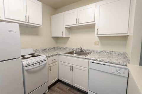 This is a photo of a kitchen with white cabinets and white appliances in a 560 square foot 1, 1 bath apartment at Park Lane Apartments in Cincinnati, OH.