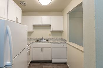 This is a photo of a kitchen with white cabinets and white appliances in a 560 square foot 1, 1 bath apartment at Park Lane Apartments in Cincinnati, OH.
