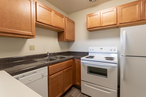 This is a photo of a kitchen with honey oak cabinets and white appliances in a 560 square foot 1, 1 bath apartment at Park Lane Apartments in Cincinnati, OH.