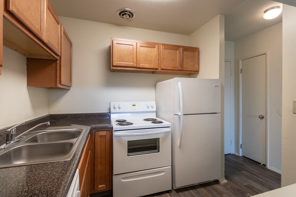This is a photo of a kitchen with honey oak cabinets and white appliances in a 560 square foot 1, 1 bath apartment at Park Lane Apartments in Cincinnati, OH.