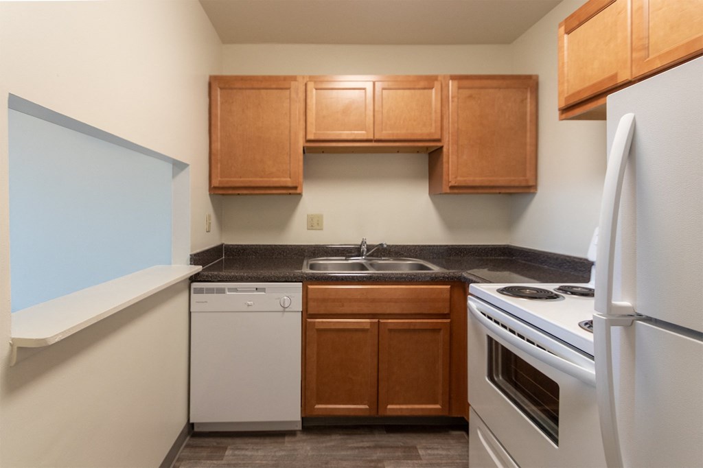 This is a photo of a kitchen with honey oak cabinets and white appliances in a 560 square foot 1, 1 bath apartment at Park Lane Apartments in Cincinnati, OH.