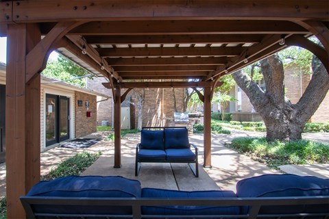 a covered patio with a couch and a swing