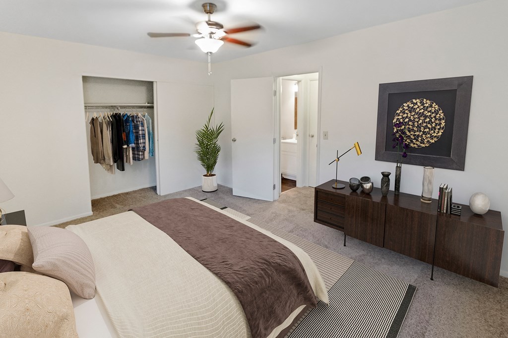 This is a photo of the digitally staged primary bedroom of a 742 square foot, 2 bedroom apartment at Romaine Court Apartments in Cincinnati, Ohio.