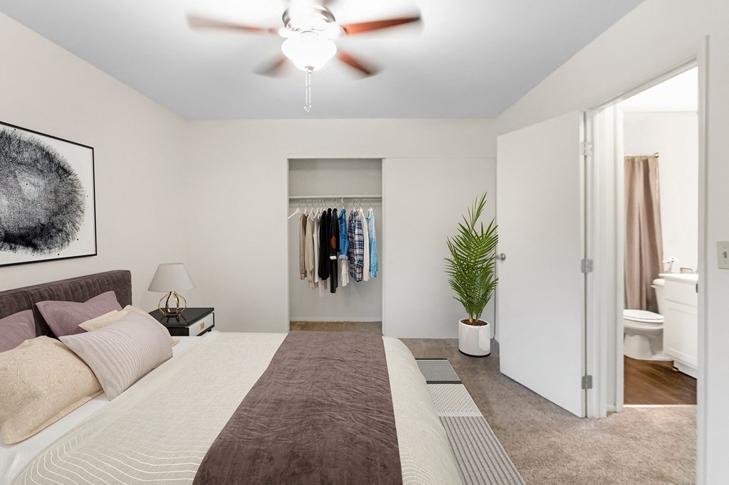 This is a photo of the digitally staged primary bedroom of a 742 square foot, 2 bedroom apartment at Romaine Court Apartments in the Oakley neighborhood of Cincinnati, Ohio.