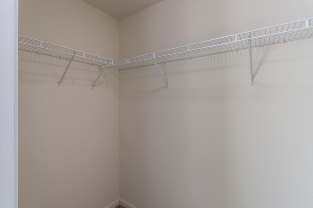This is a photo of the primary bedroom walk-in closet in the 1226 square foot 3 bedroom, 2 bath Hambletonian at Trails of Saddlebrook Apartments in Florence, KY.
