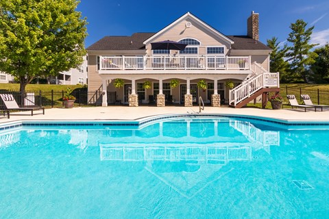 A house with a pool in front.