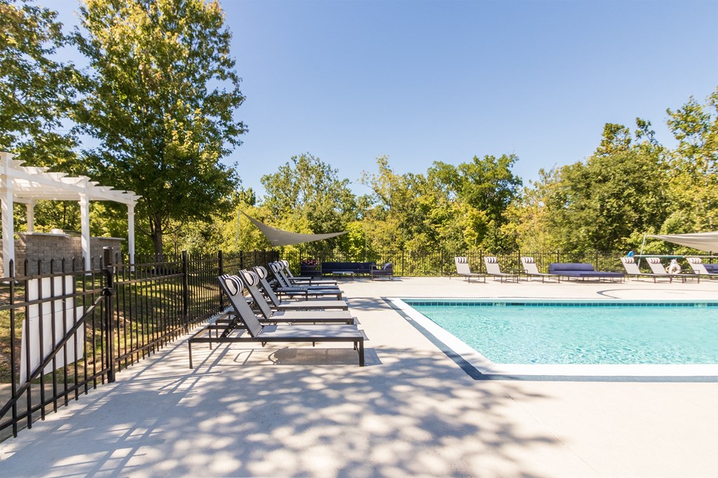 a swimming pool with chaise lounge chairs next to a resort style pool