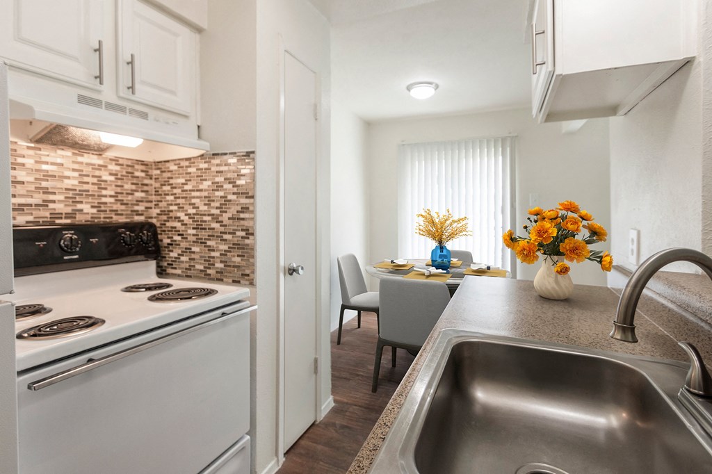 This is a photo of a virtually staged kitchen looking into dining area in the 640 square foot 1 bedroom apartment at The Summit at Midtown Apartments in Dallas, TX.