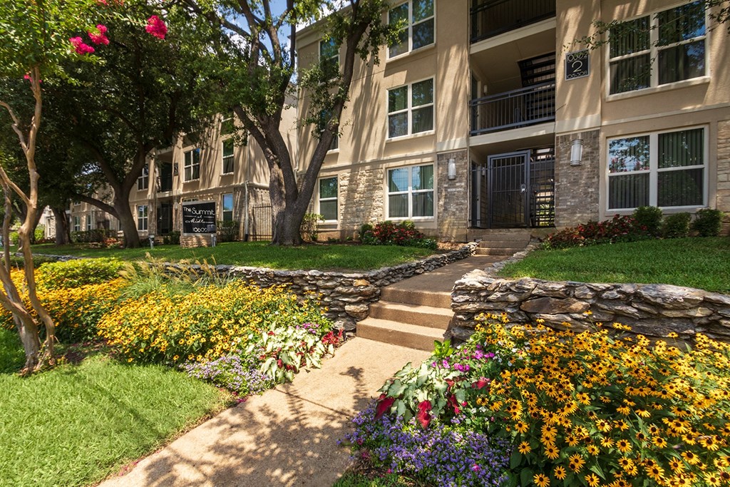 This is a photo of building exteriors and the grounds at The Summit at Midtown Apartments in Dallas, TX.