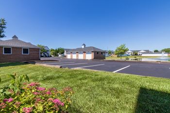 This is a photo of a pond with a fountain and detached garages at Washington Place Apartments in Miamisburg, Ohio in Washington Township.
