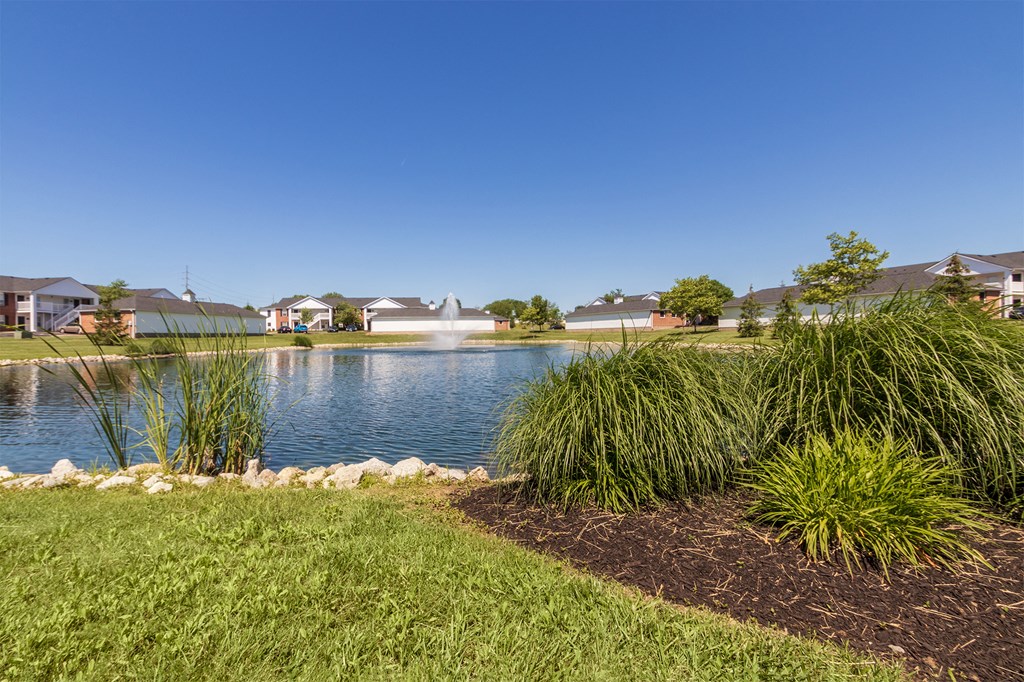 This is a photo of a pond with a fountain and building exteriors at Washington Place Apartments in Miamisburg, Ohio in Washington Township.