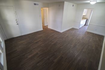 This is a photo of hardwood vinyl flooring in the living room of the 751 square foot 1 bedroom apartment at Woodbridge Apartments in Dallas, TX.