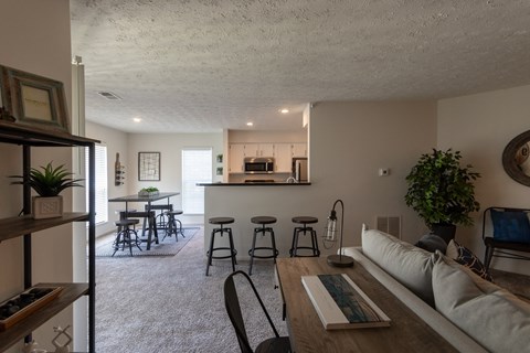 a living room with a couch and a kitchen with a bar