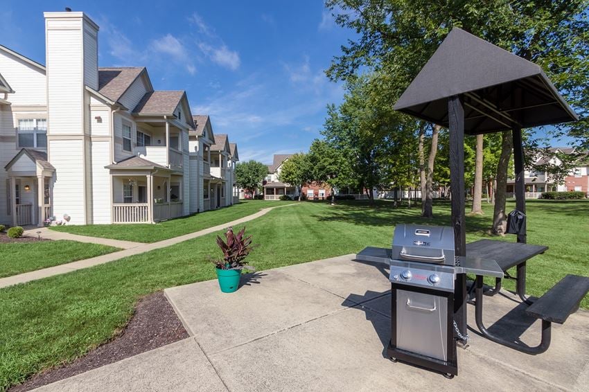 This is a photo of a BBQ grilling station and apartment exteriors at The Sanctuary at Fishers in Fishers, IN.