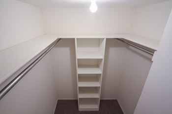 This is a photo of the one of the two walk-in closets in the bedroom of the 751 square foot 1 bedroom apartment at Woodbridge Apartments in Dallas, TX.
