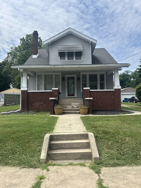 A house with a grey roof and a brick chimney.