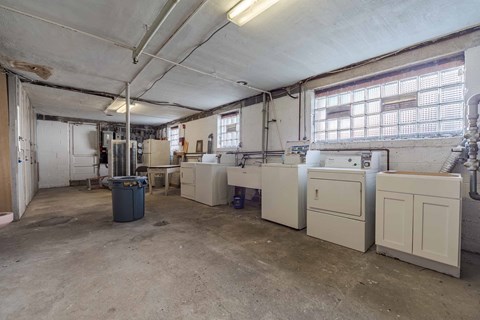 A large, empty industrial space with white cabinets and a trash bin.