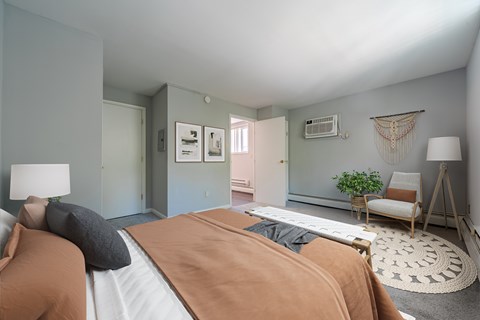A bedroom with a large bed and a chair.