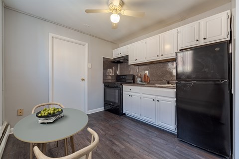 A kitchen with black appliances and white cabinets.