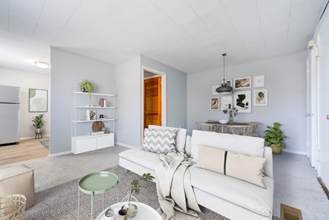 A white couch with a grey throw blanket on it sits in a living room.