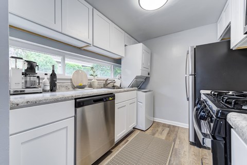 A kitchen with white cabinets and stainless steel appliances.