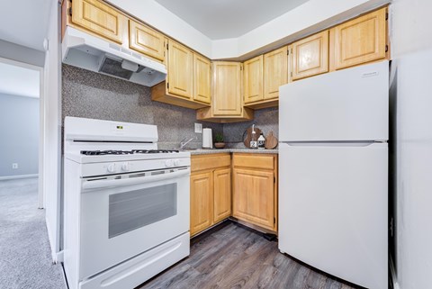A kitchen with wooden cabinets and white appliances.