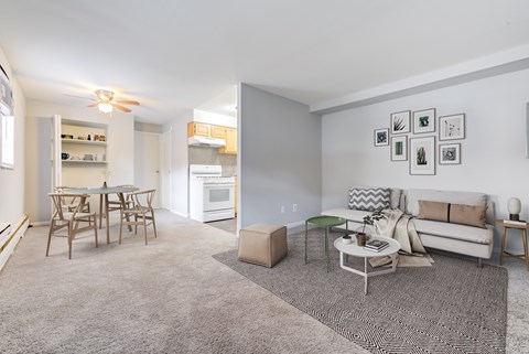 A living room with a grey carpet and a white sofa.